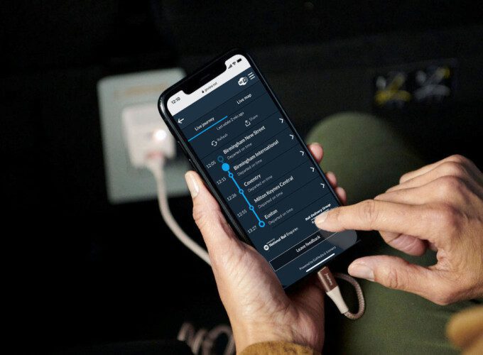 Icomera Real-time Journey Information sq Hands holding a smartphone. Real-time information regarding the journey is displayed on the phone screen.