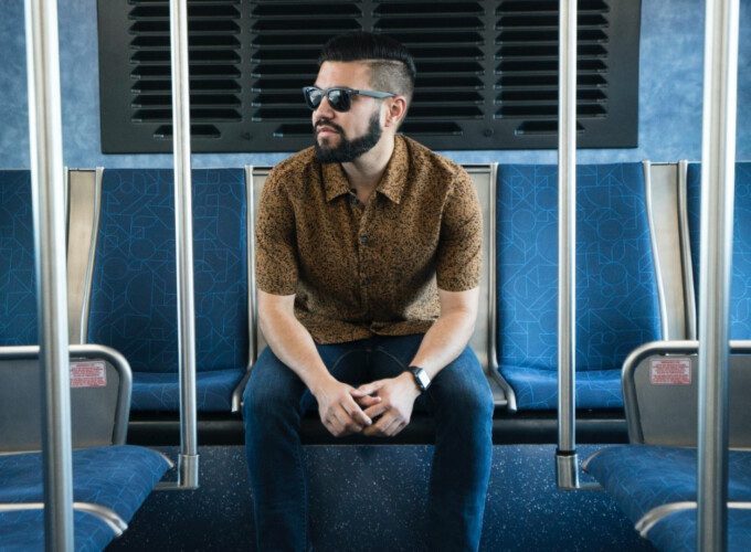 Equity in Transit Systems Hero A male passenger wearing sunglasses on a train