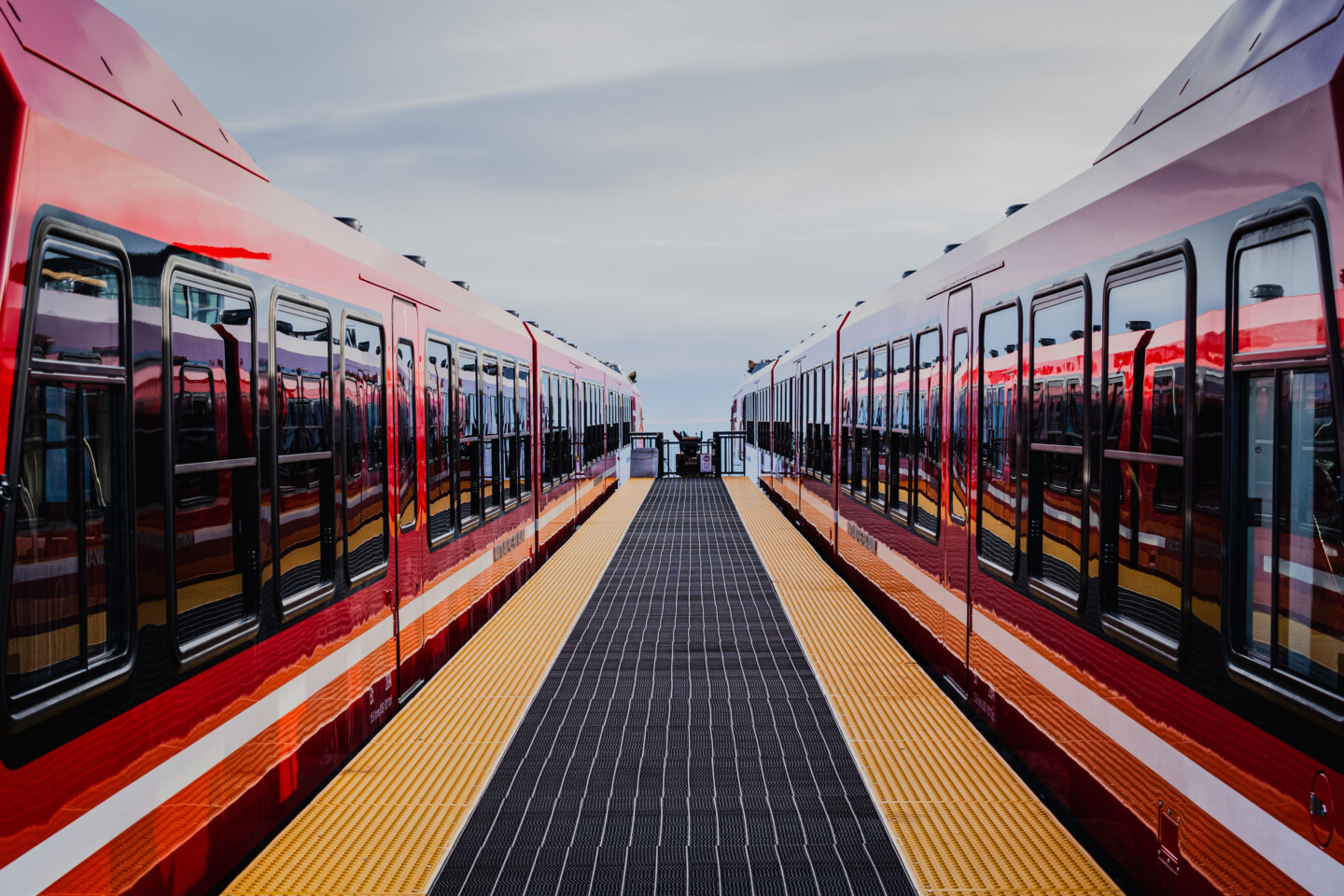 Two red trains on a station platform